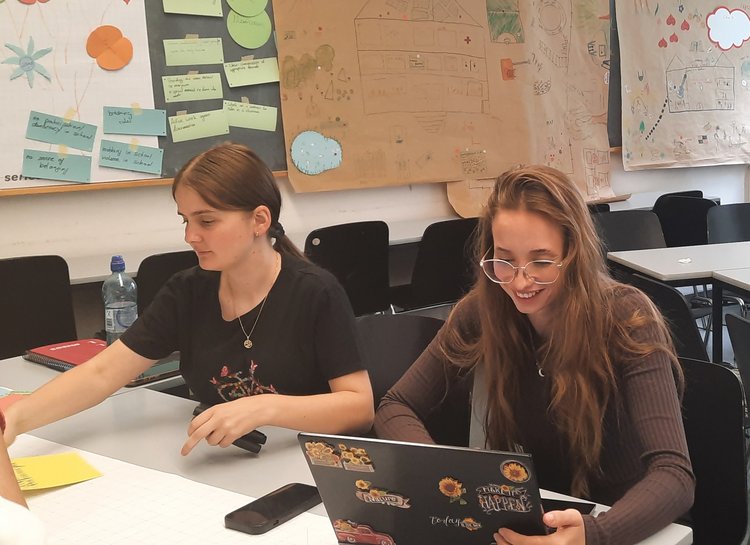 2 Studierende der Sommerschule sitzen an einem Tisch