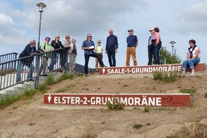 Ein Teil der Exkursionsgruppe an einem ehemaligen Braunkohlentagebau mit geologischen Zeitmarkern