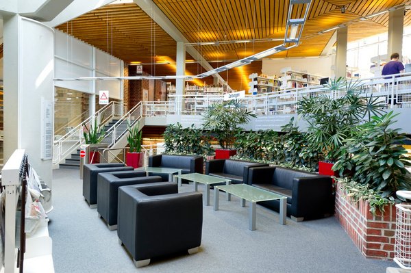 Interior view of the library with seating area in the foreground and bookshelves in the background (photo: University of Vechta/Meckel) 