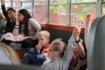 Einige Kinder sitzen im MO•KU•LAB-Bus und zeigen mit dem Finger auf.