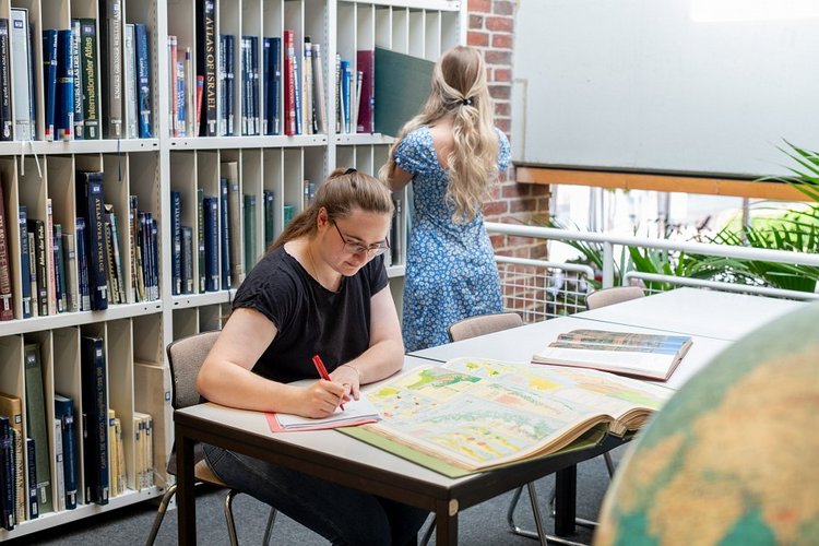 Studentin studiert Karten in der Bibliothek der Universität Vechta (Bild:Universität Vechta/Wollstein/bitters.de)