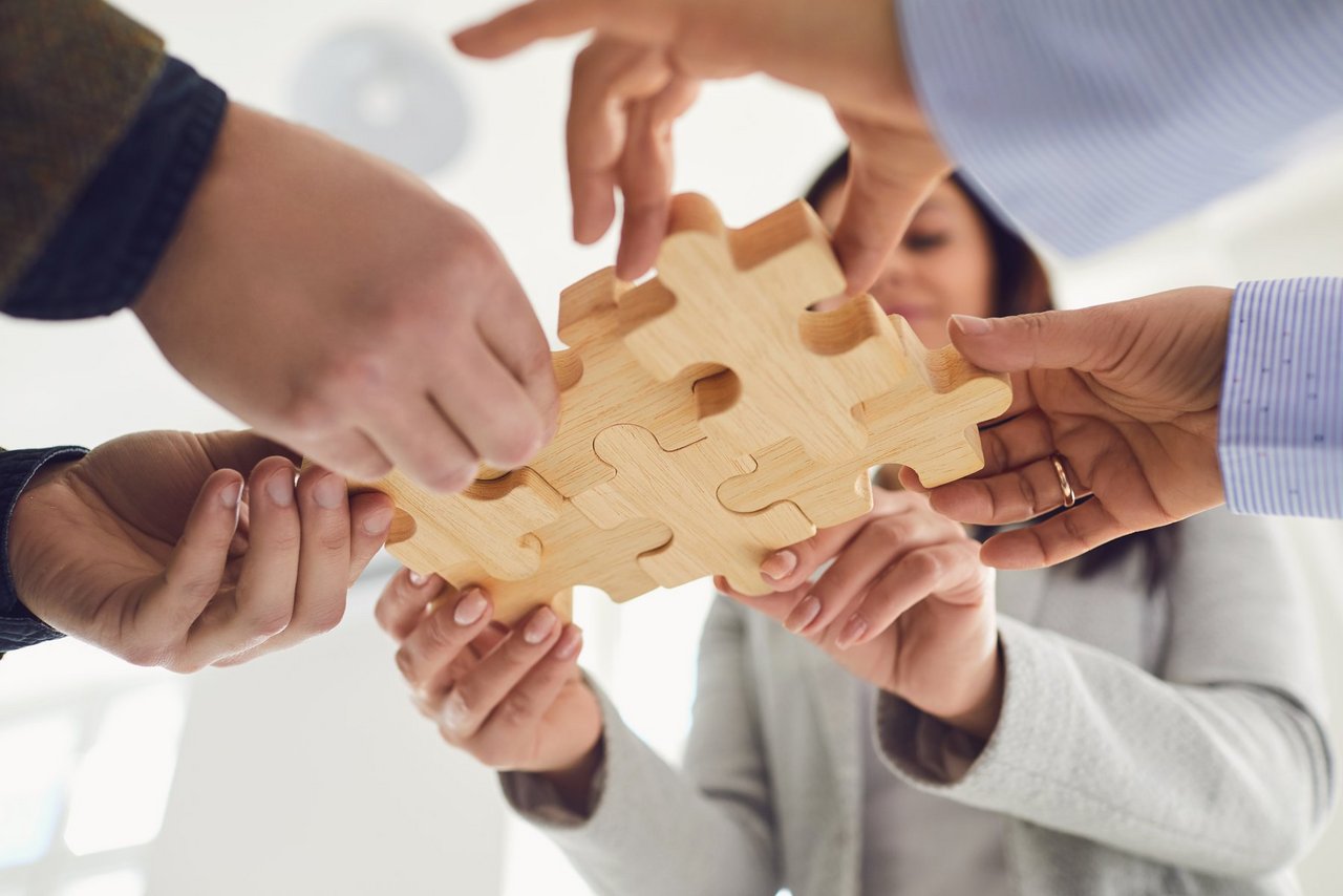 Business people holding wooden gears in their hands connect at a business meeting in the office. Concept of partnership creative work startup startup teamwork team business people.