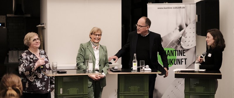 Diskussionsrunde vor dem Banner der Veranstaltung "Kantine Zukunft"