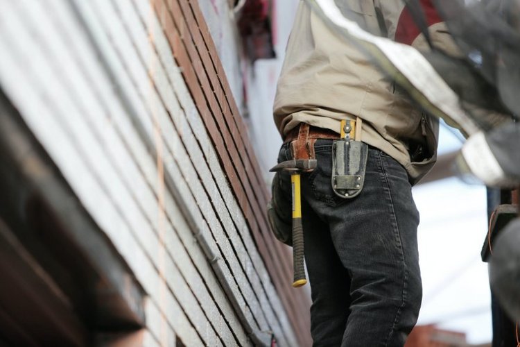 Handwerker mit Hammer in der Hosentasche