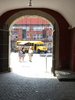 Blick durch einen Torgogen auf den Innenhof des Schloßes. Im Hintergrund steht der gelbe MO•KU•LAB Bus