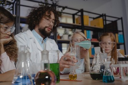 Lehrer führt chemische Experimente mit einer Schulklasse durch