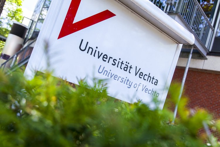 Ein weißes Schild mit der Aufschrift "Universität Vechta", das am Haupteingang steht.