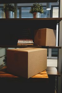 Packkartons und Bücher in einem Regal