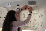 Ein Mädchen zeichnet auf einer Wandzeitung ein neues Bild