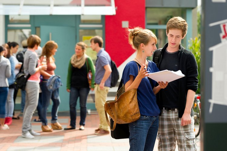 Studentinnen und Studenten in Grüppchen vor Gebäude