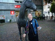 Frau vor der Pferdskulptur