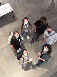 Sechs Personen mit FFP2-Maske, die im Kreis stehen und nach oben sehen. Es handelt sich um Teilnehmer_innen an der GDM 2022 von der Universität Vechta aus dem Fach Mathematik.