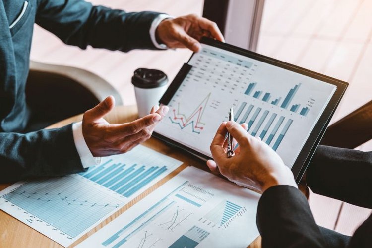 Zerbor/AdobeStock Personen sprechen über über verschiedene Diagramme
