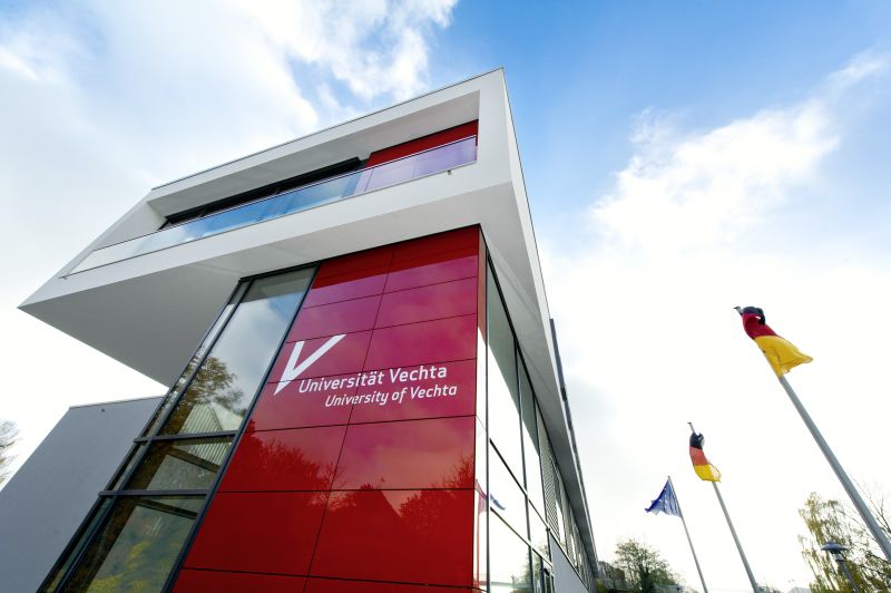 Q-Gebäude von außen mir roter Wand und Universität Vechta Logo