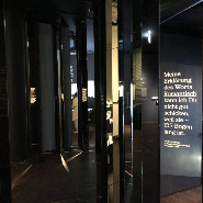 Hohe Spiegel und dunkle Tafeln mit weißer Schrift in der Ausstellung