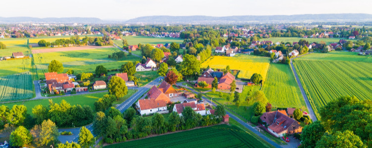 Dorf mit wenigen Häusern in ländlicher Region aus Vogelperspektive. 