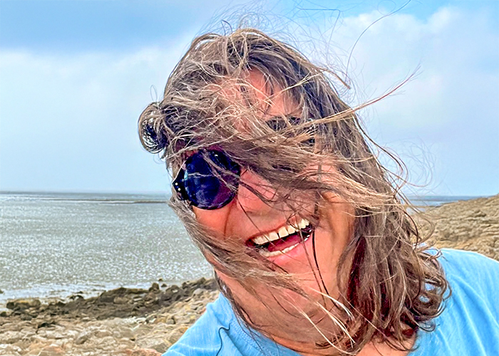 lachender Marco Sagurna am Strand mit Sonnenbrille