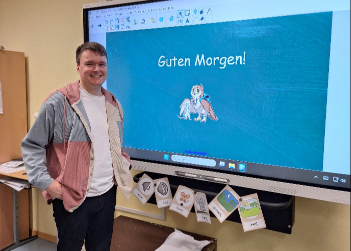 Portrait des Alumni Nils Privenau im Klassenraum vor Screen