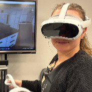 Eine Person mit einer XR-Brille steht vor einem Monitor.