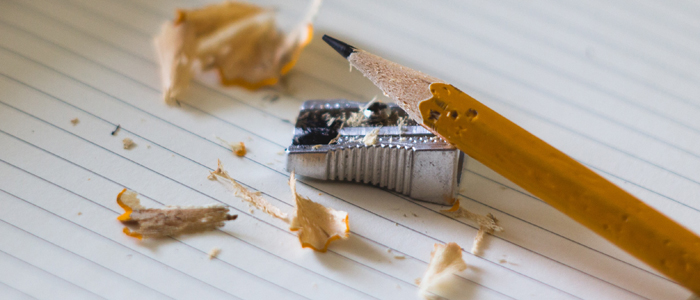 Stift und Anspitzer auf leerem Schreibpapier
