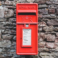 Ein roter Briefkasten vor einer Ziegelwand